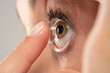 © vladimirfloyd - young woman wearing contact lens.