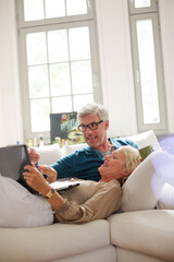 Older couple relaxing together on living room sofa