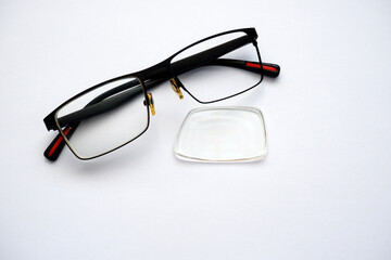 Glasses with a dropped lens on a white background. The lens is not broken