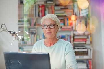 Wall Mural - Businesswoman smiling at computer in home office