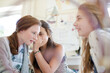 Three teenage girls gossiping in room