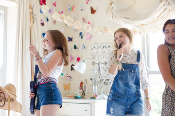 Wall Mural - Three teenage girls playing music and singing in bedroom