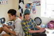 © KOTO - Two teenage boys using electronic devices in room