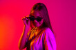 © Lustre Art Group  - Cropped stylish young caucasian girl wearing black fashionable sunglasses isolated on neon background
