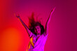 © Lustre Art Group  - Full-length portrait of young beautiful girl in motion with hands up isolated on colorful yellow pink red background in neon