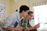 Fototapeta Na drzwi - Two teenage boys having fun while using digital tablet