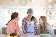 Three teenage girls playing with beanie in dining room