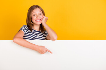 Canvas Print - Portrait of positive pupil hand on cheek indicate finger empty space promotion isolated on yellow color background