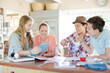 © KOTO - Group of smiling teenagers taking photo in dining room