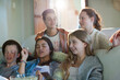 © KOTO - Group of teenagers having fun while watching tv on sofa