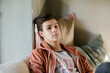 Teenage boy lying on sofa and thinking