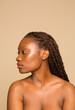 © Phiwo Ndlovu/Cultura Creative - Studio portrait of shirtless woman with braided hair