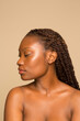 © Phiwo Ndlovu/Cultura Creative - Studio portrait of shirtless woman with braided hair and eyes closed