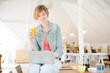 © KOTO - Portrait of woman sitting at desk with laptop in office