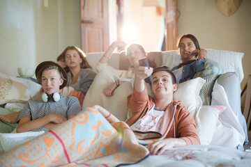 Wall Mural - Group of teenagers watching tv on sofa together