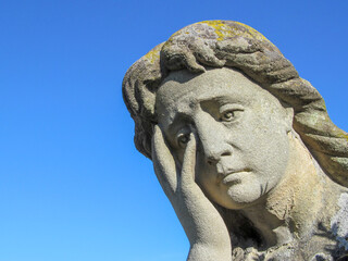 Wall Mural - A stone monument to a woman with an extremely sad and tragic expression
