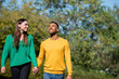 © PhotoAlto - Smiling young couple walking together in public park