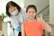 © Jeanette Goh - Asian child being vaccinated.Children vaccination by nurse.Medical doctor vaccinating school student in the arm.Paediatrician injecting vaccine to students in clinic.Girl thumb up.