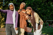 Portrait Of Three Young Women Wearing Hijabs In Park