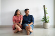 © IndiaPix - Young newlyweds sitting together in their apartment.