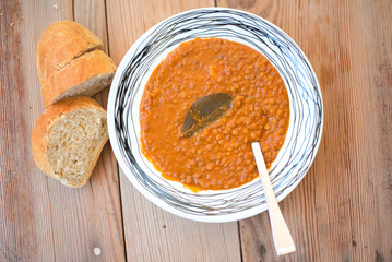 Wall Mural - Lentil soup , on a wooden table, traditional Greek food