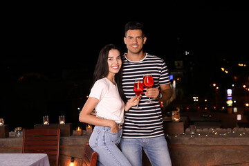 Canvas Print - Romantic couple with glasses of cocktails on cafe terrace at night