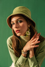 Fashion Portrait Of Elegant Woman With Green Eyes Makeup, Wearing Trendy Green Bucket Hat, Turtleneck Sweater. Total Color Look, Outfit