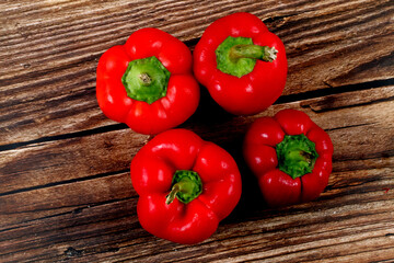 Canvas Print - Closeup of fresh red bell peppers on a wooden surface