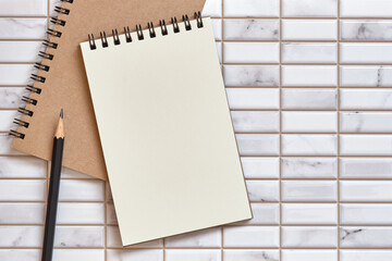 Wall Mural - open blank notebook and pencil on white tile background, flat lay concept, copy space for text, top 