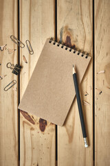 Wall Mural - top table view, notebook on wooden desk with black pencil, flat lay copy space for text.