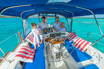 Wall Mural - Senior and young couples, family, enjoying sailing trip on a luxury summer holiday vacation, sunny weather and ocean in background, love and romance on a beautiful yacht