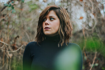 Poster - Young female dressed in a black dress in the forest in autumn