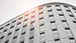 © Grand Warszawski - Modern architectural details. Modern glass facade with a geometric pattern. Contemporary corporate business architecture. Red sun on horizon. Black and white toned image.