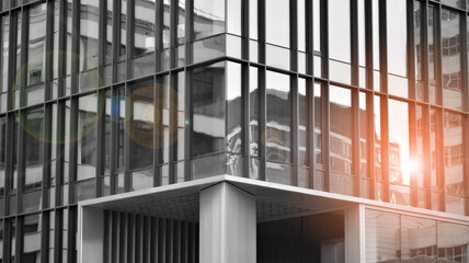 Wall Mural - Modern architectural details. Modern glass facade with a geometric pattern. Contemporary corporate business architecture. Red sun on horizon. Black and white toned image.