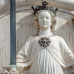 Wall Mural - Ancient aged sculpture of beautiful Noble woman with sword and papyrus at Doge Palace in Venice, Italy, closeup, details