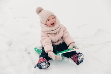 Canvas Print - Portrait of a girl playing in the snow during a winter walk and playing snowballs, rolling and skating in the snow