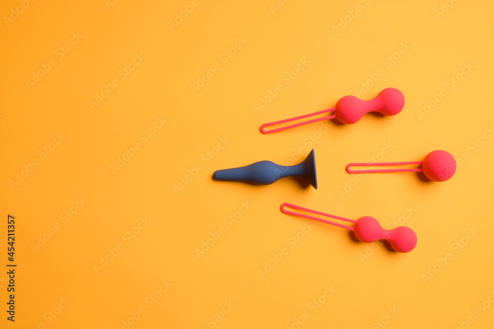 Anal black plug and three red balls, on a yellow background.sex shop - obrazy, fototapety, plakaty 