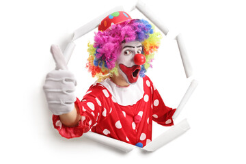 Canvas Print - Cheerful clown peeking through a paper hole and gesturing thumbs up