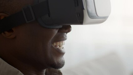 Wall Mural - African Man Experiencing Virtual Reality Wearing VR Headset Indoors, Cropped