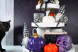 canvas print picture - Halloween Farmhouse 3 three tier tray decorated with purple, white and orange pumpkins, skull, lollipops and black plaid gnomes, with black cat.