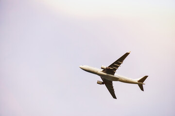 passenger plane is flying far away against the blue summer and cloudy sky with copy space