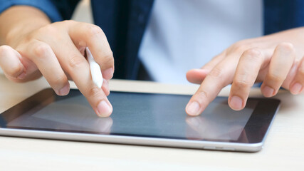 Wall Mural - Close up of man hand writing on digital tablet while working at home, online study, telecommunication