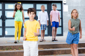 Wall Mural - Smiling preteen schoolchildren boy and girl walking home after finishing lessons on summer day