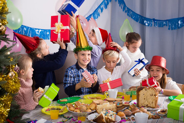 Wall Mural - Cheerful exchanging gifts during Christmas dinner