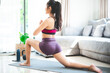 © chokniti - young Asian woman exercise by yoga at home gym, healthy female lifestyle with fitness sport training at home, girl doing body active physical exercise indoor house room, relaxation and wellness