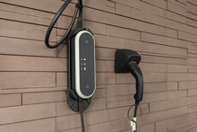 Power Supply For Hybrid Electric Car Charging Battery On Wall Brick Background. Eco-car Concept.