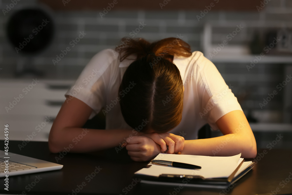 Young depressed businesswoman in dark office