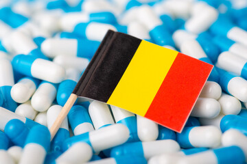 Flag of Belgium on piles of pills. Concept of negative health situation among citizens of the country