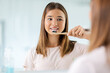 © Syda Productions - dental care, hygiene and people concept - happy smiling teenage girl with toothbrush brushing teeth at bathroom