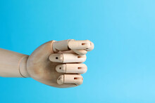 Wooden Mannequin Hand Showing Fig Sign On Light Blue Background. Space For Text